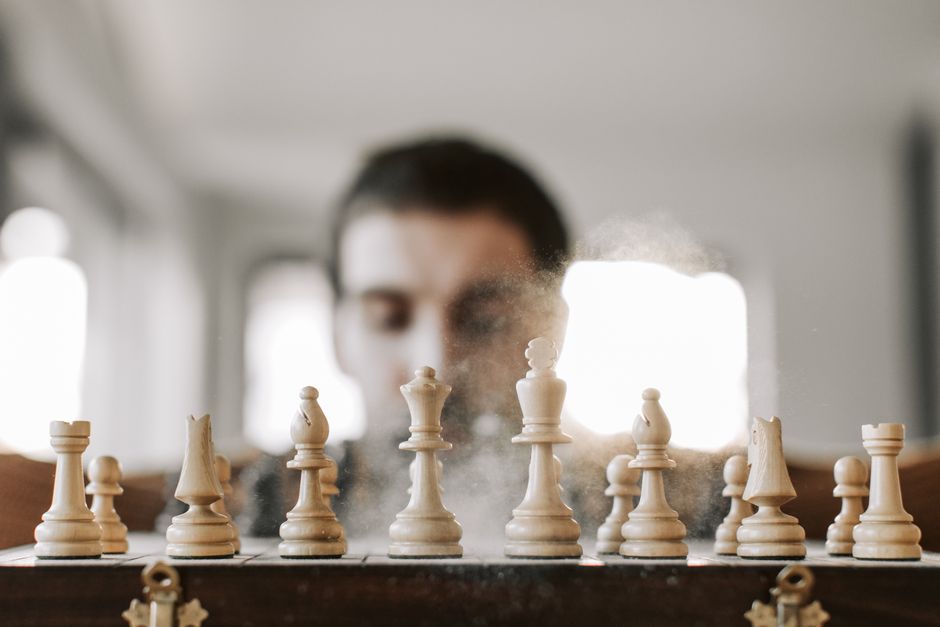 Close-up of a chessboard with chess pieces in action, representing strategy and concentration.
