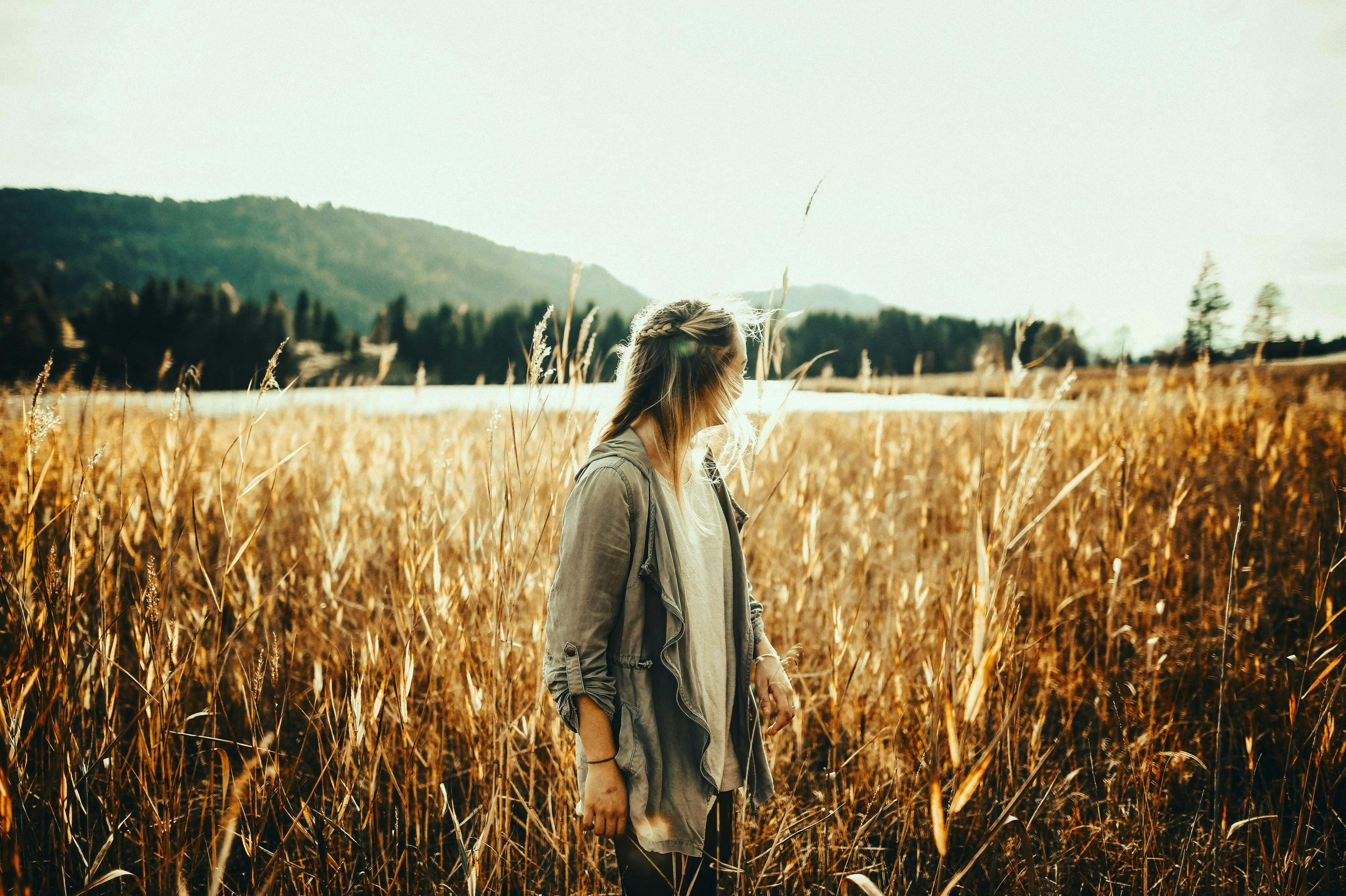 A woman standing in the middle of the field. | Photo: Pexels