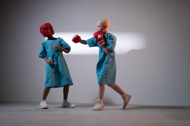 Child Wearing A Hospital Gown And Boxing Gloves