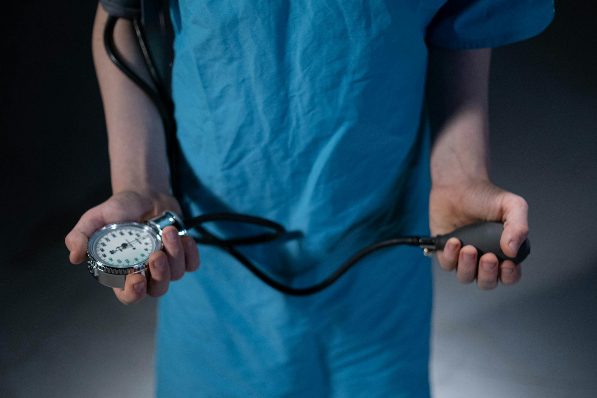 Patient Holding the Inflation Bulb and Blood Pressure Gauge of a Sphygmomanometer