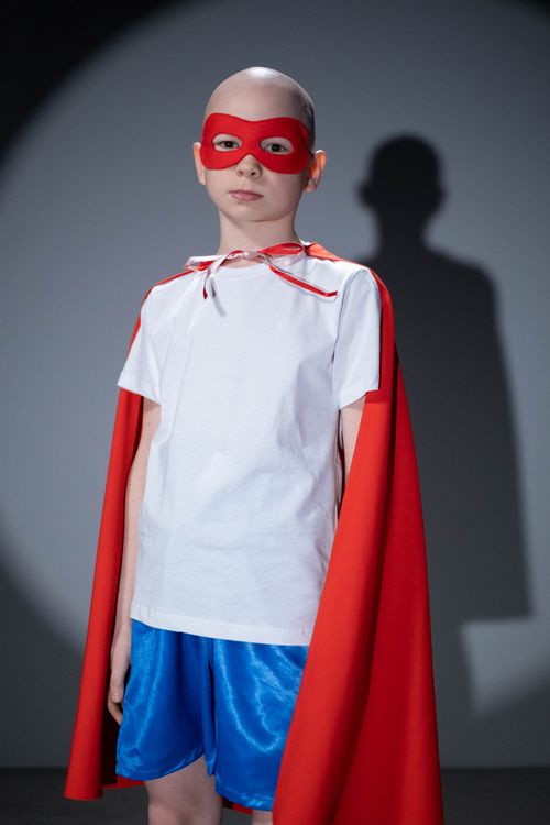 Free A young child wearing a superhero outfit with a red cape and mask, standing confidently. Stock Photo