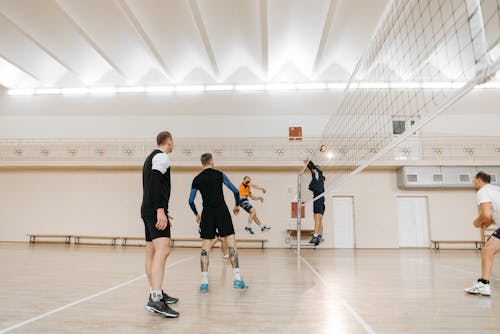 Men Playing Volley Inside a Covered Court