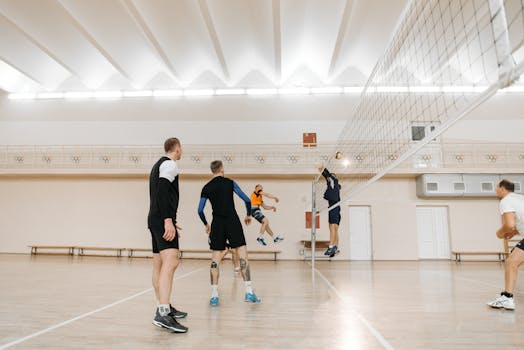 Dynamic volleyball game with players in action, showcasing teamwork and skill indoors.