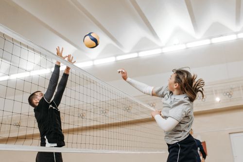 Free Two athletes engaged in a thrilling volleyball match indoors, showcasing competitive spirit and energy. Stock Photo