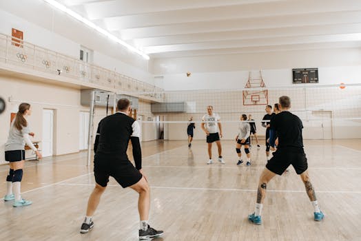 Energetic volleyball match with mixed team players engaging in a competitive game indoors.