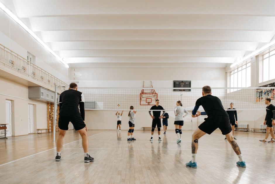 Volleyball players in a competitive indoor match, focusing on teamwork and skill.
