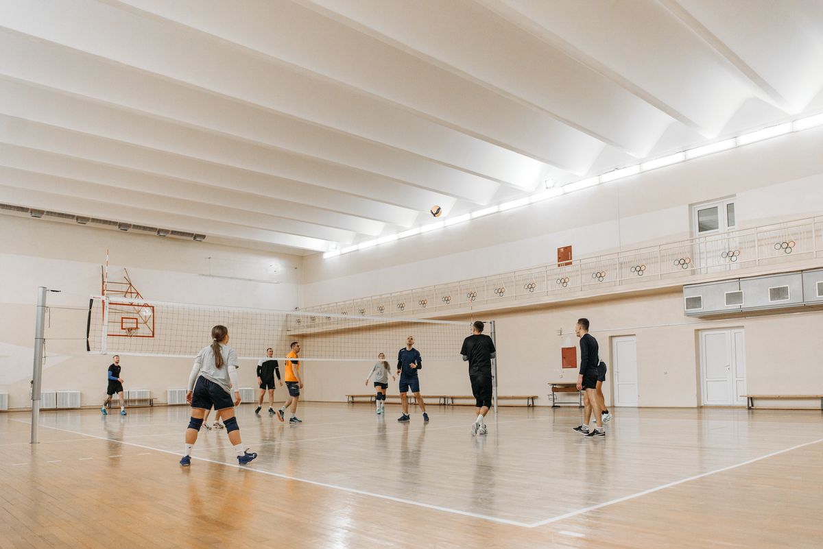Jugadores sobre cancha de voleibol de madera