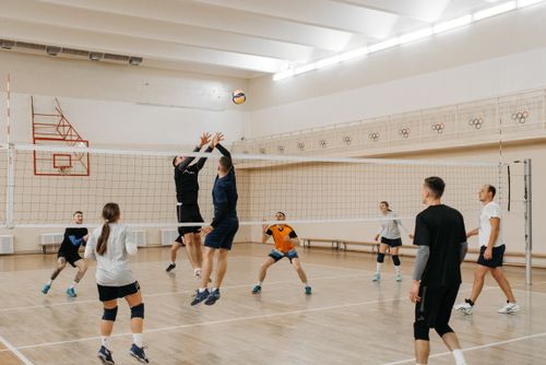 Free A dynamic indoor volleyball game with players in mid-action. Stock Photo