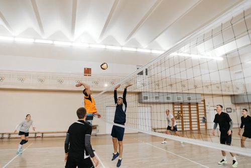 Free Dynamic scene of a competitive indoor volleyball game with players in action. Stock Photo