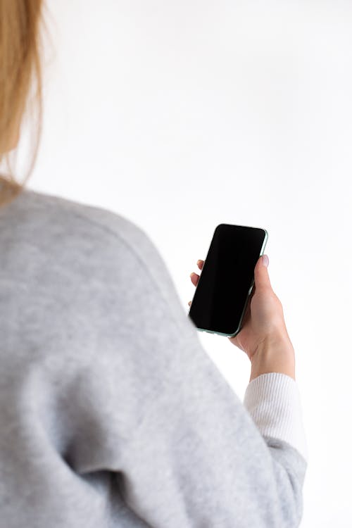 Ücretsiz Gri Uzun Kollu Gömlekli Siyah Smartphone Tutan Kadın Stok Fotoğraflar