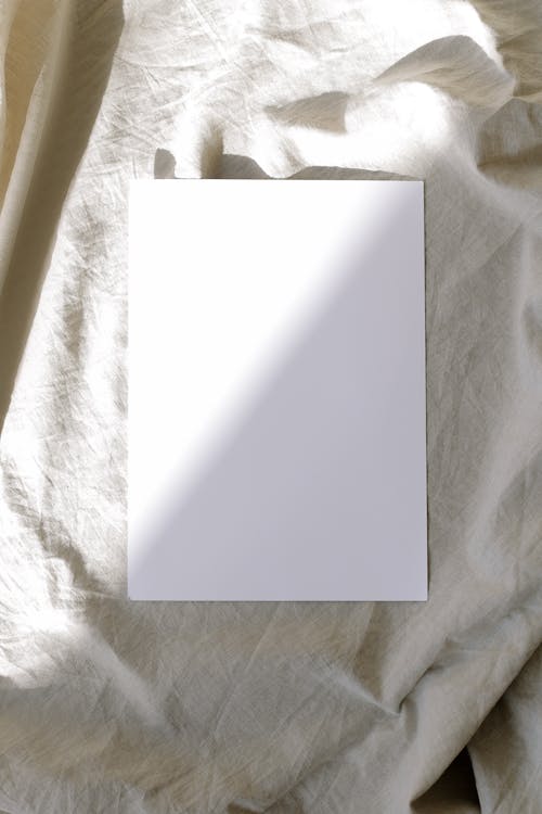 Free Blank Paper on Top of a Fabric Stock Photo