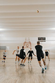 Energetic indoor volleyball game with six players competing on the court.