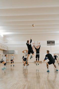 Male athletes compete fiercely in an indoor volleyball match.