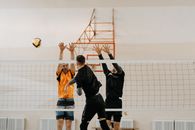 Volleyball Players Spiking a Ball Through Blockers