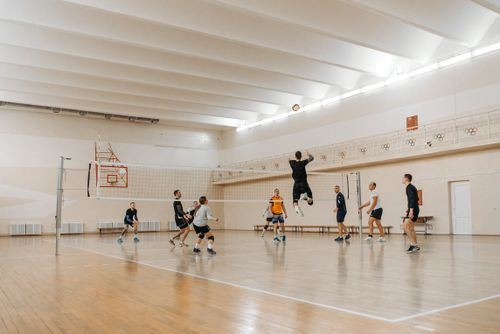 Free Players in an intense volleyball match indoors, showcasing athleticism and teamwork. Stock Photo
