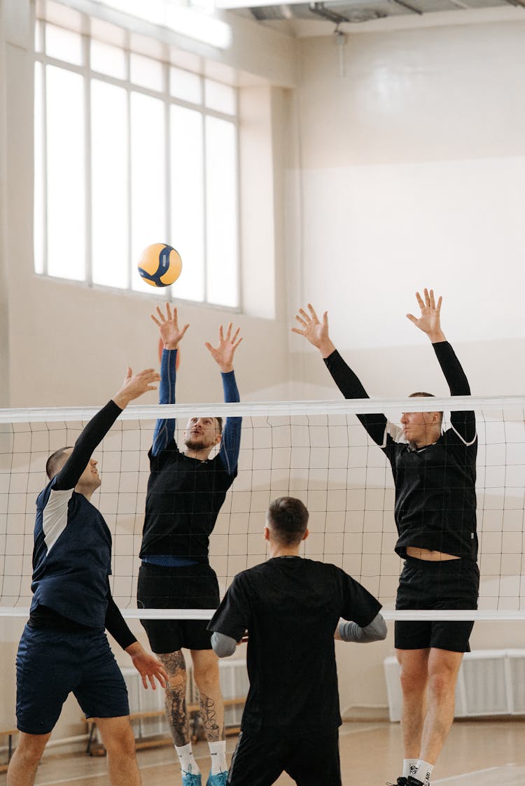 Volleyball Players Blocking A Ball