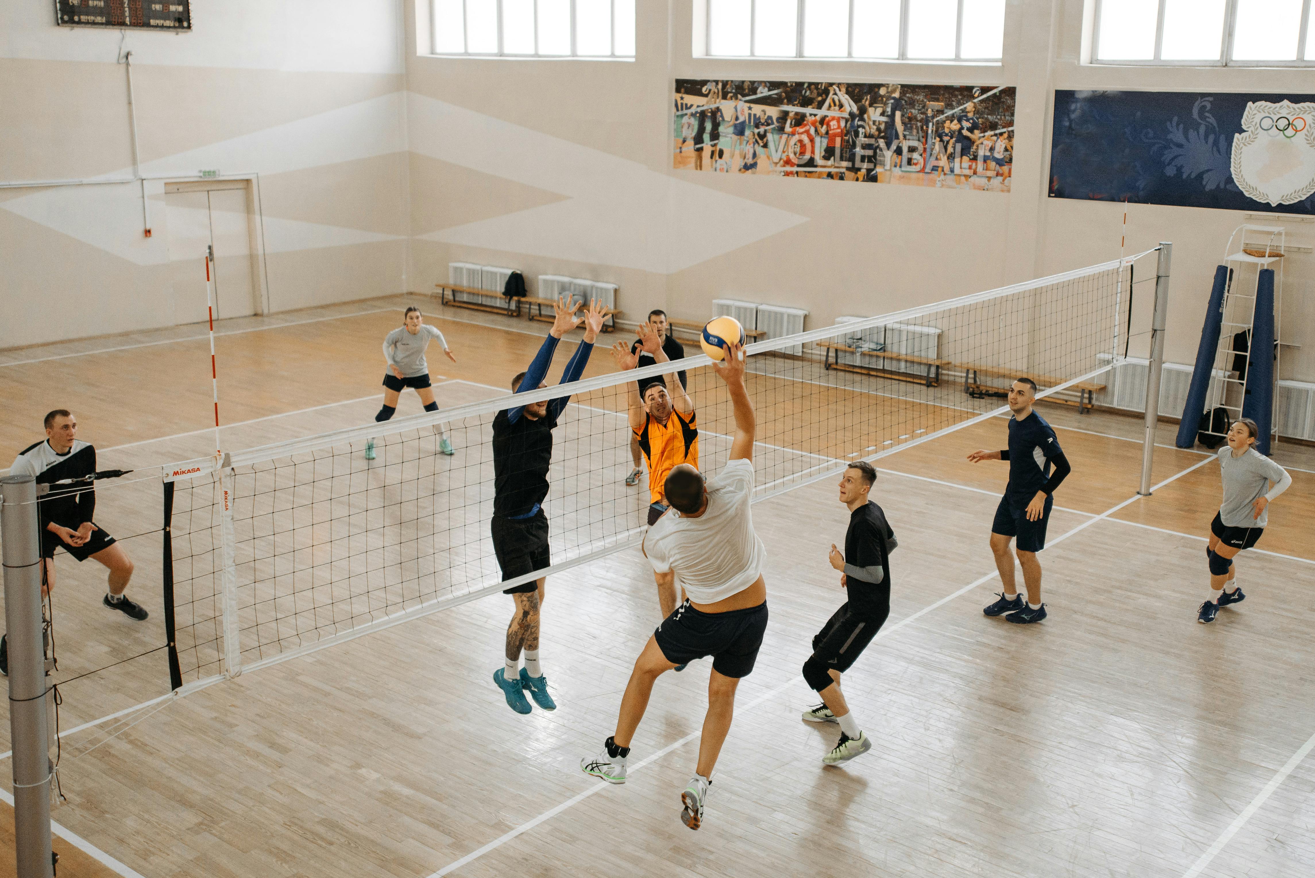 athletes on volleyball court playing