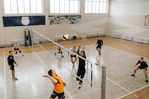 Player Jumping near Net with Arms Raised