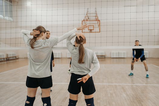 Volleyball players planning strategy during an indoor game, showing teamwork and communication.