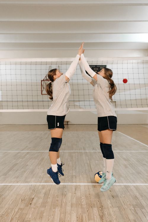 Free Two female volleyball players practicing indoors, showcasing teamwork in action during a training session. Stock Photo