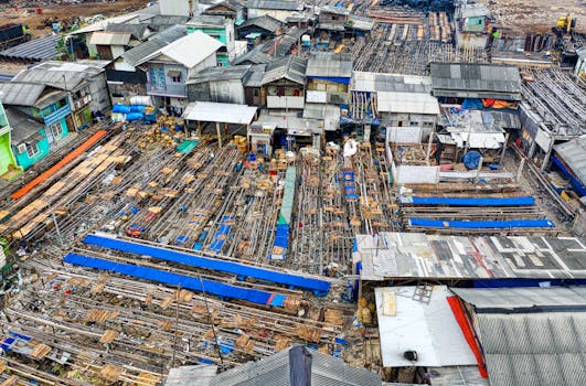 Drone view of typical residential houses of poor town around landfill polluting environment