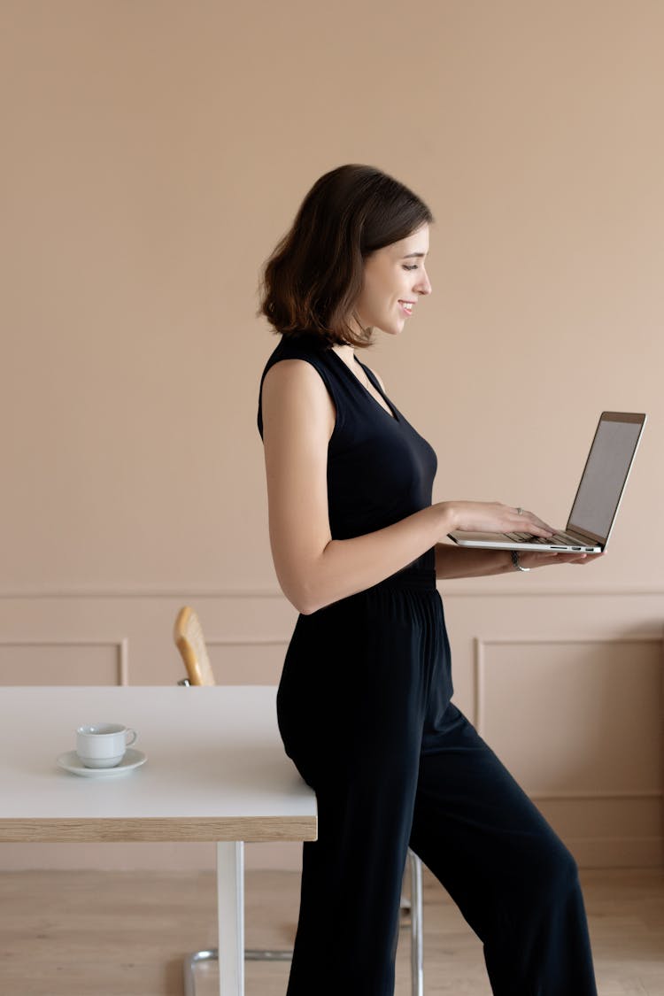 A Woman Standing While Using Laptop