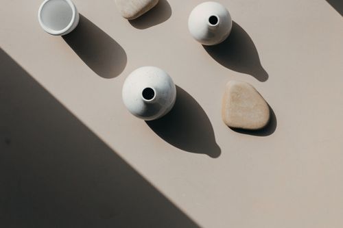 Free Aesthetic overhead composition of ceramic vases and stones casting artistic shadows. Stock Photo