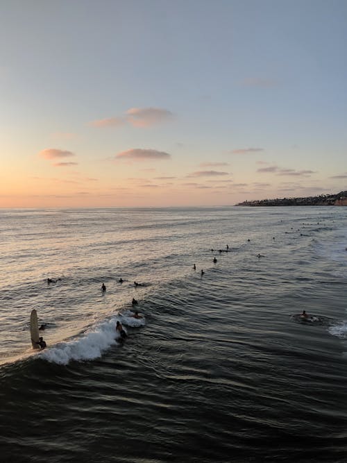 Gens Sur La Plage Pendant Le Coucher Du Soleil