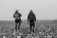 Grayscale Photo of Two Men Carrying Rifles