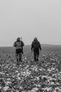 Grayscale Photo of Two Men Carrying Rifles
