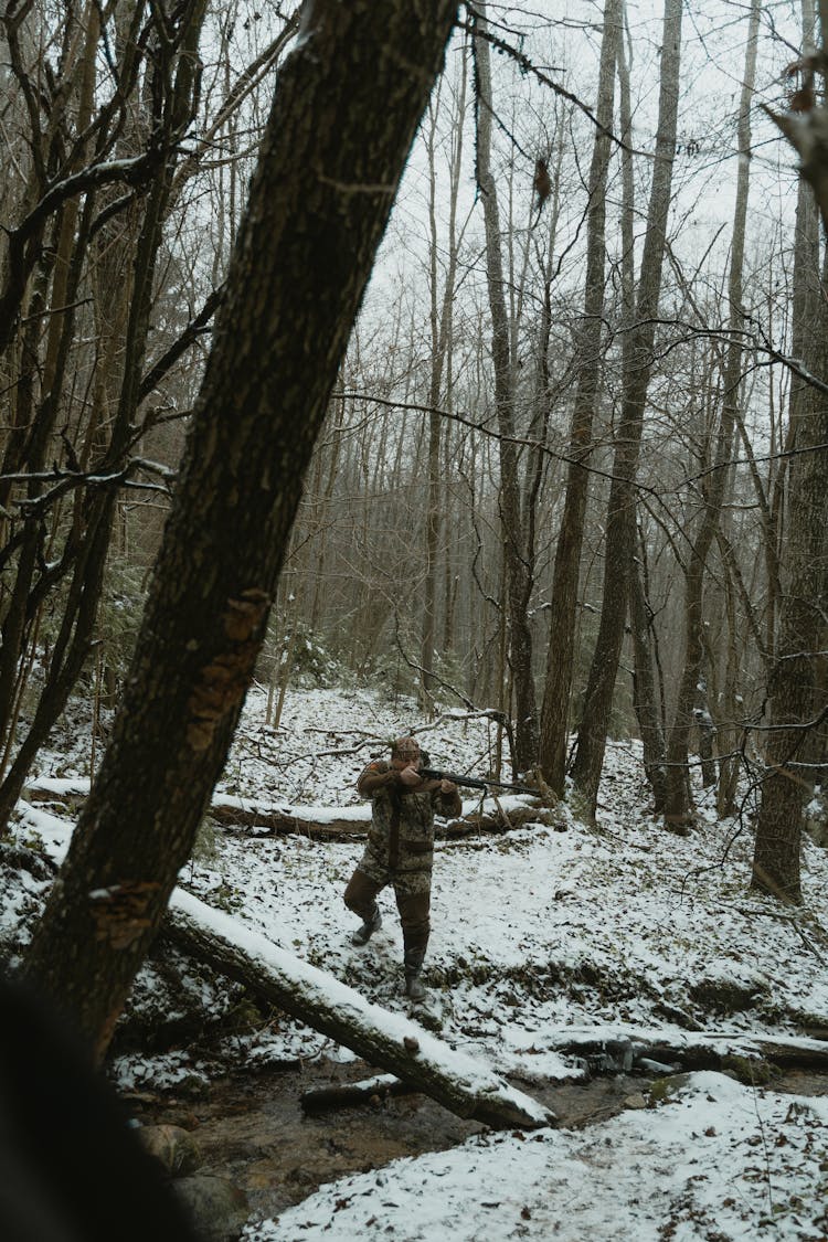 Man Carrying A Riffle Hunting In The Forest