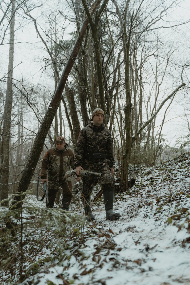 Two Men In Camouflage Walking In The Woods