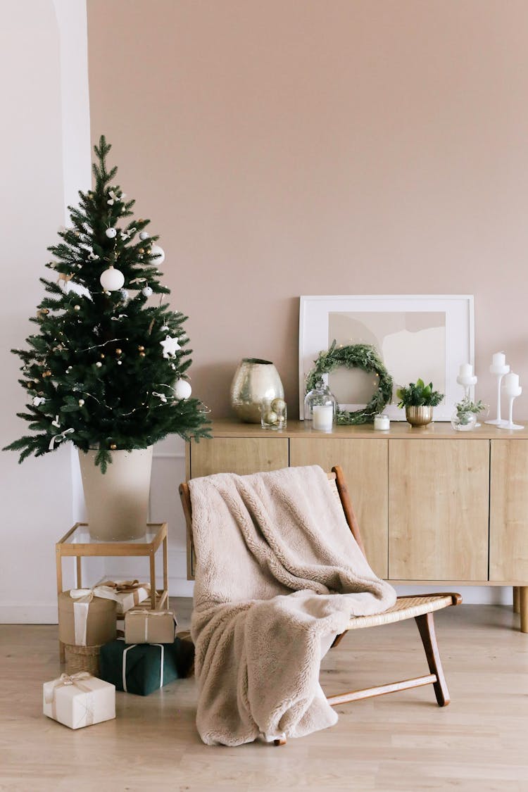 Green Christmas Tree With White Baubles And White Wall