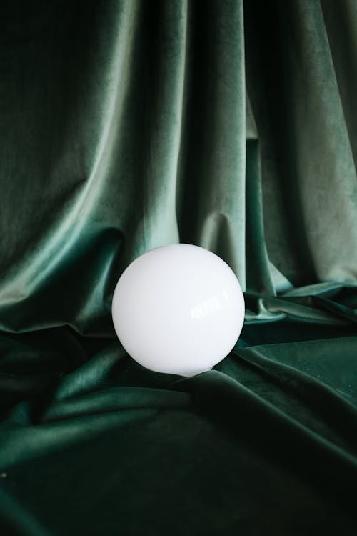Белое яйцо на зеленой ткани