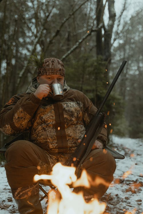 Man in Brown Camouflage Jacket Drinking Coffee