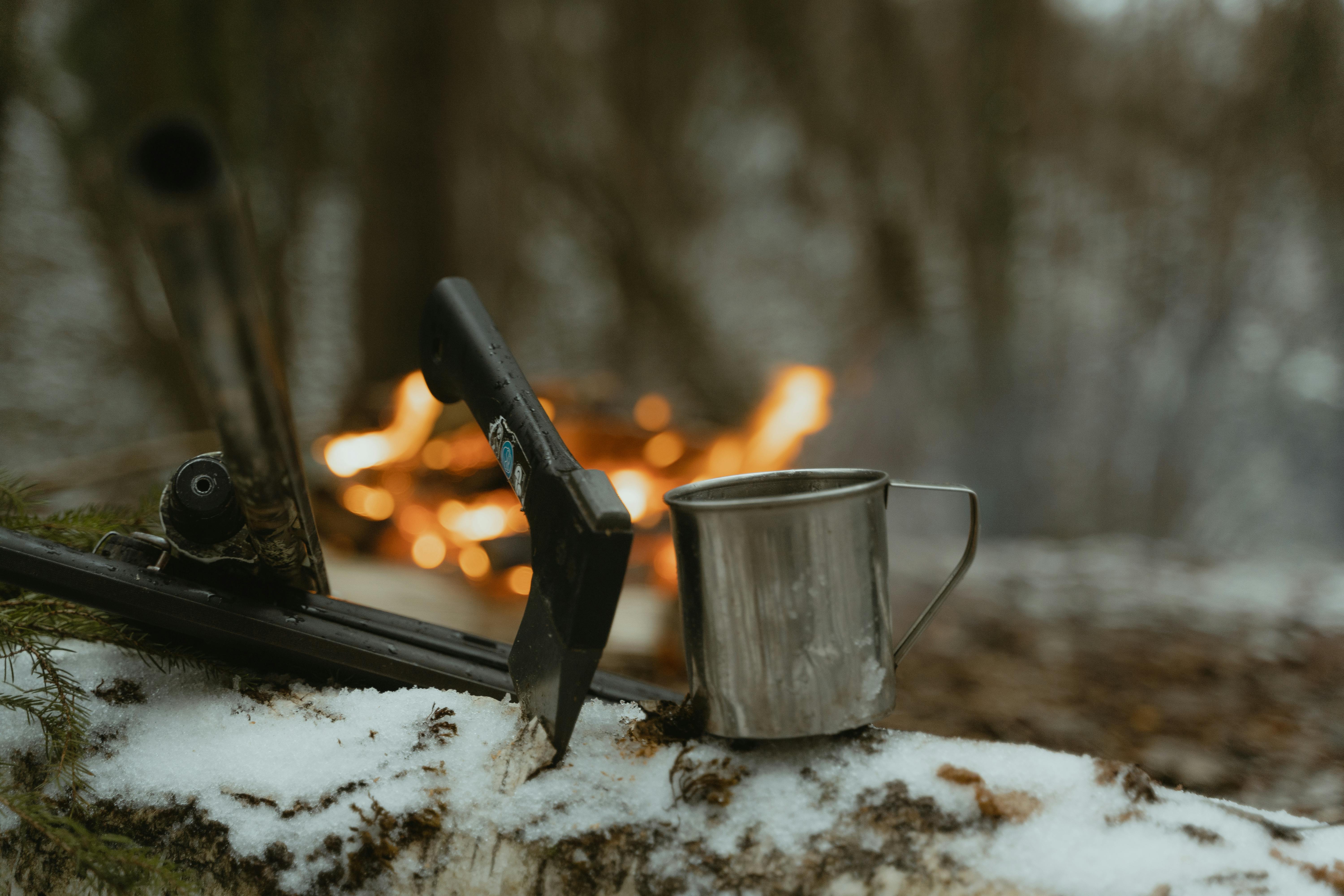 black handled knife on stainless steel cup on white snow