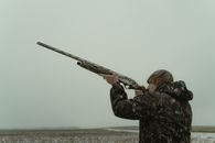 Man in Camouflage Clothes Aiming His Firearm