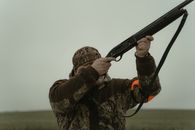 Photo of a Man in Camouflage Clothes Aiming His Gun