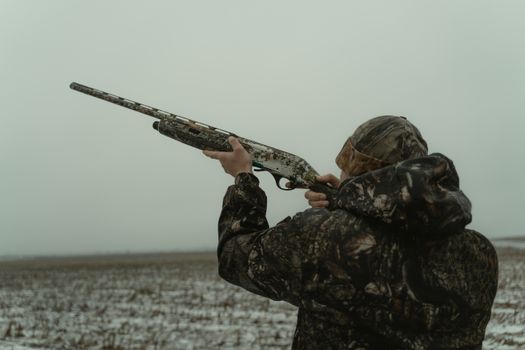 Photo of a Man in Camouflage Clothes Aiming His Firearm