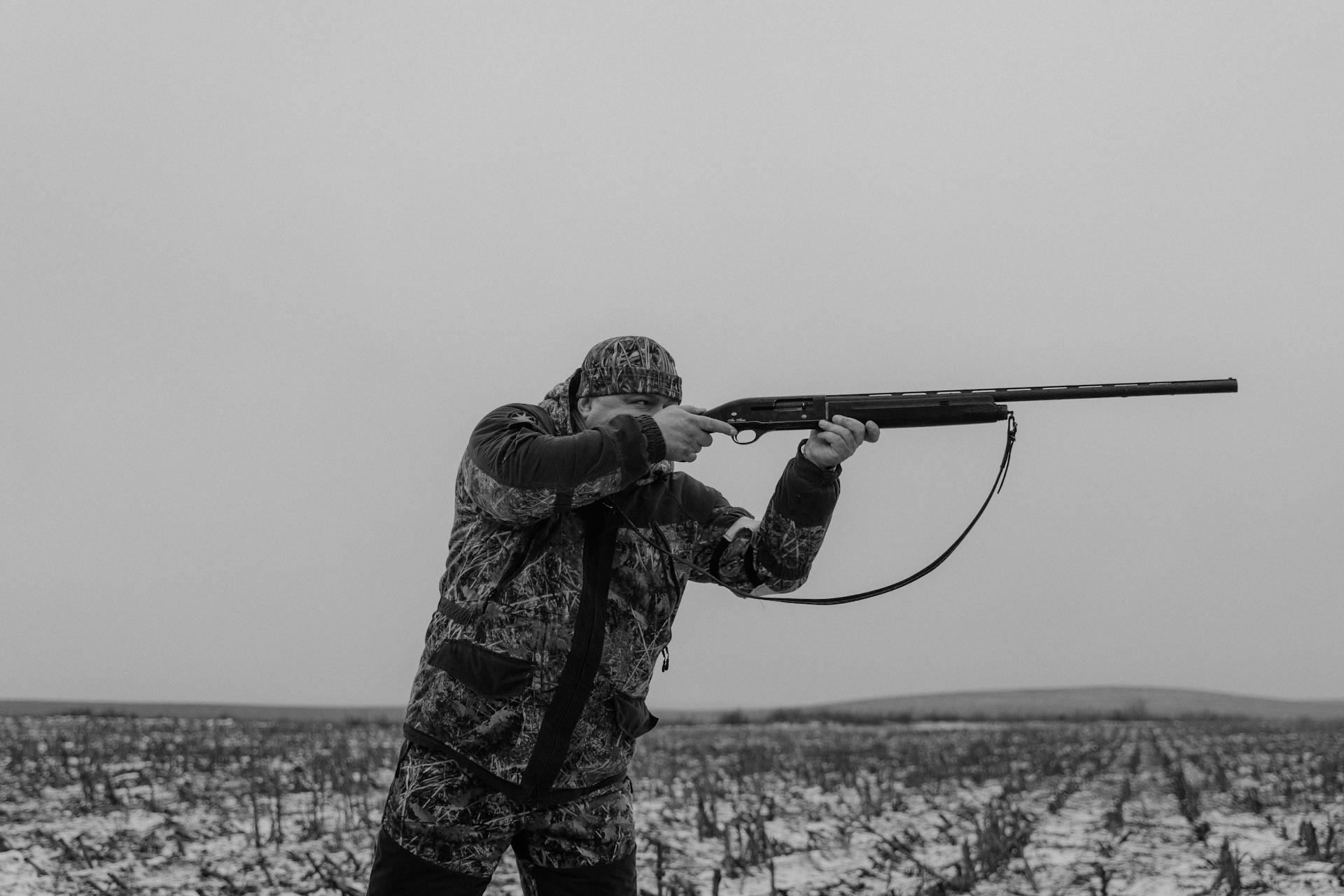 Monochrome Photo of a Hunter Aiming His Gun