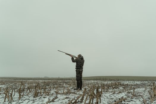 Man in Black and Brown Camouflage Jacket Standing on Snow Covered Ground