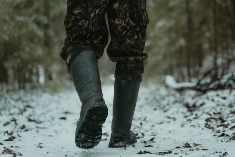 Photograph Of A Person With Black Boots Walking On The Snow