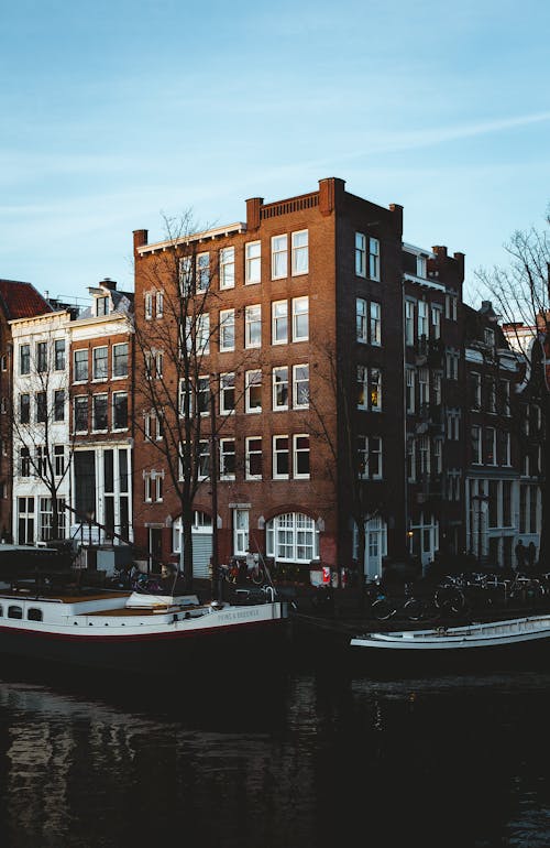 Free Old houses on canal embankment with boats in city Stock Photo