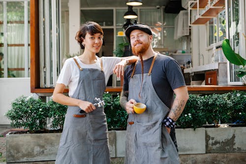 Free Couple of barista coworkers spending time in street near cafe Stock Photo