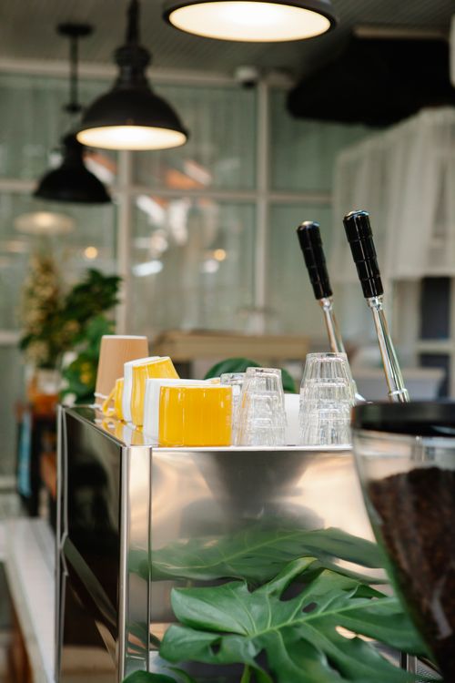 Free Cafe interior with counter and coffee machine near glasses and cups under lamps Stock Photo