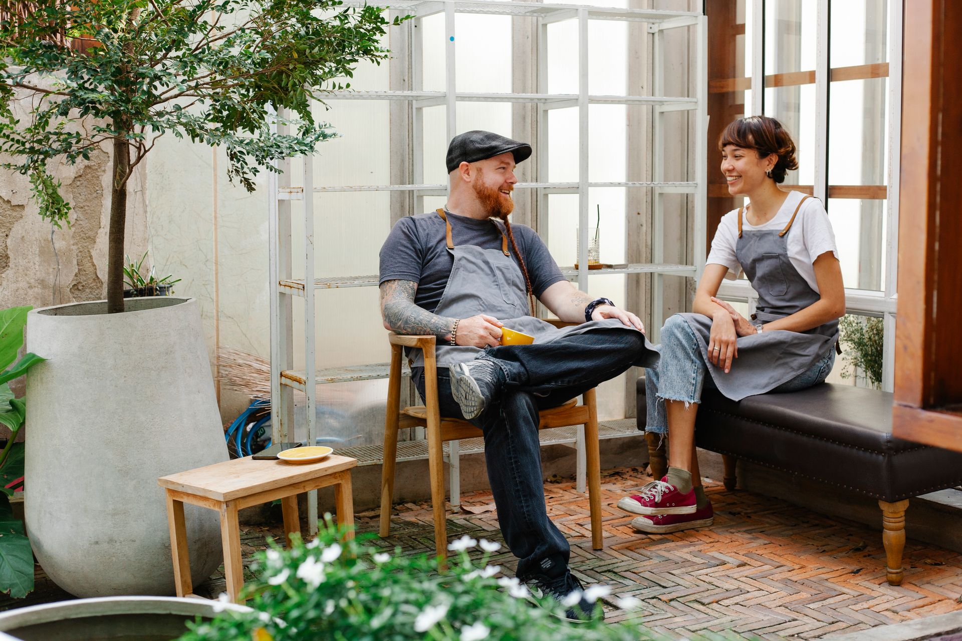Two café employees enjoying a friendly conversation outside, taking a coffee break.