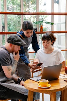 A diverse group of coworkers collaborating over coffee in a lively cafe setting.