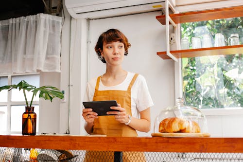 Free Baker with tablet at counter in cafe Stock Photo