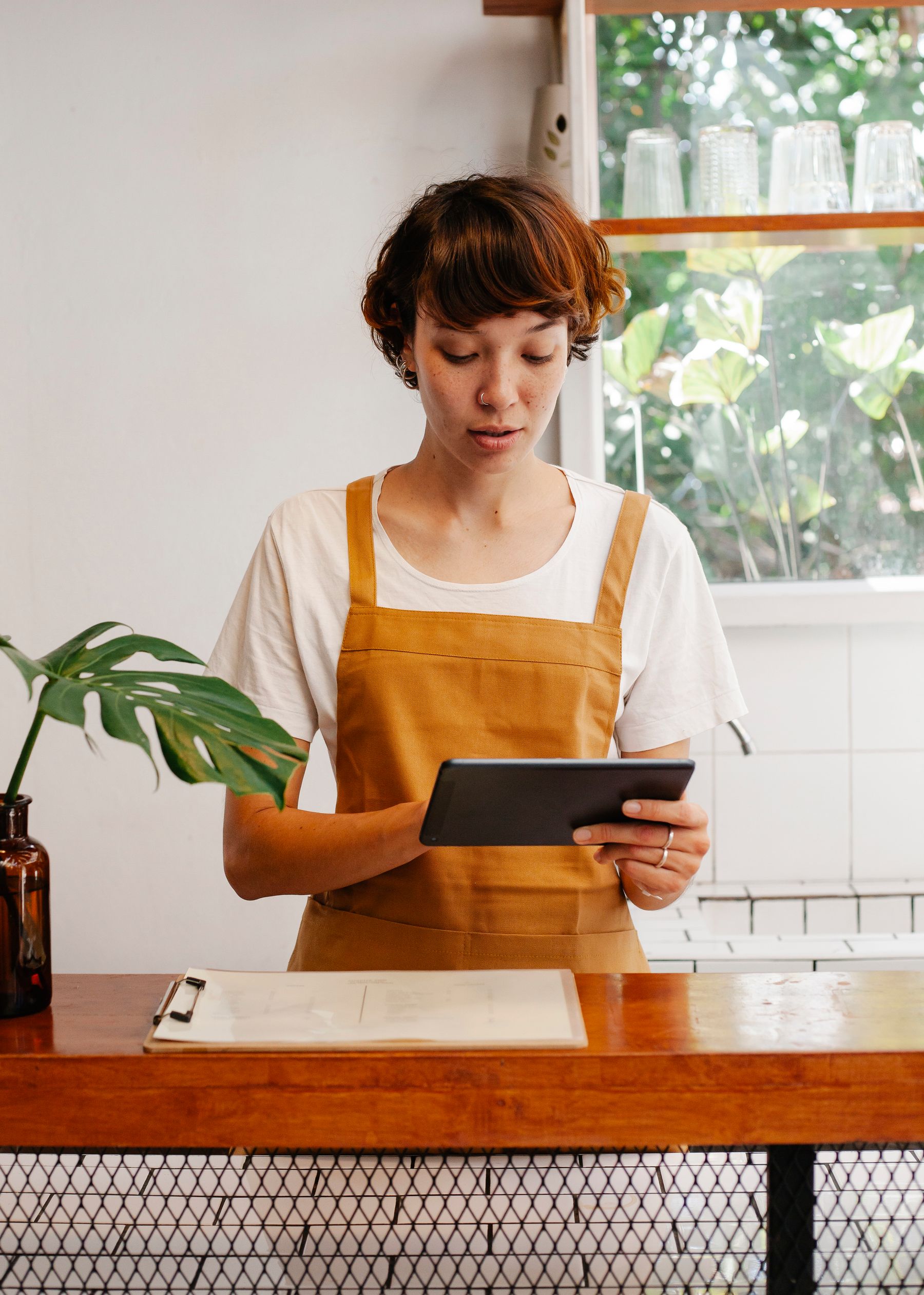 Persona trabajando con una tableta en la operación diaria de una cafetería