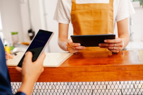 Free Crop anonymous female colleagues surfing internet on cellphone with black screen and tablet in cafe Stock Photo